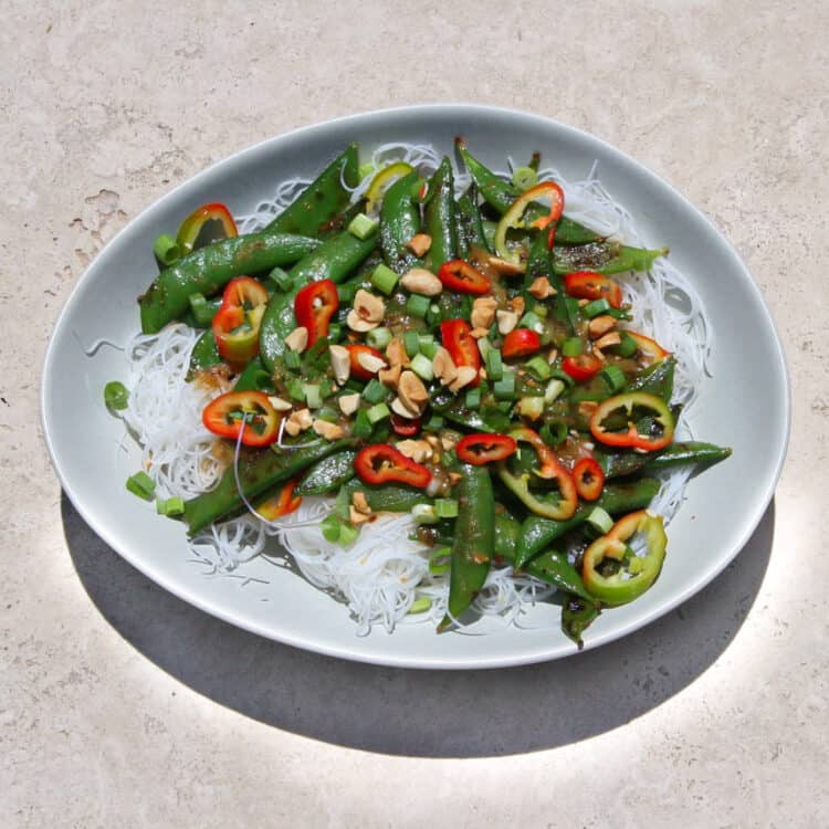 Miso Sugar Snap Peas on vermicelli rice noodles with chilis and peanuts