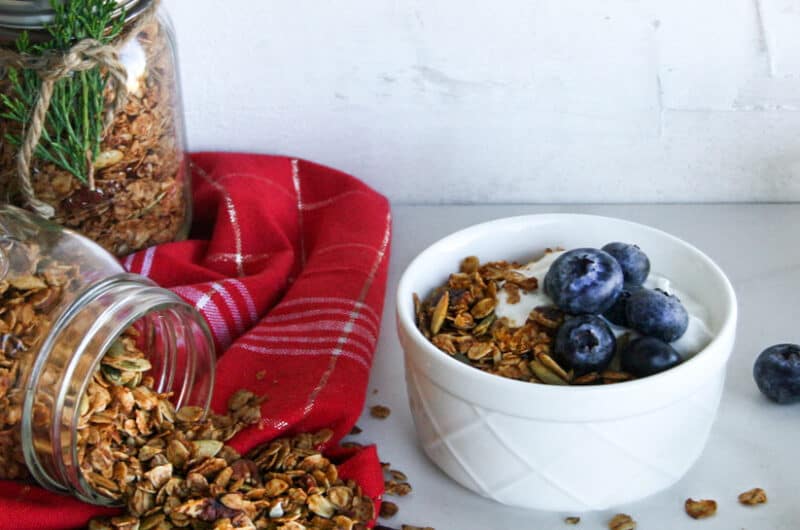 Gingerbread granola on the side and in a bowl with yogurt and blueberries