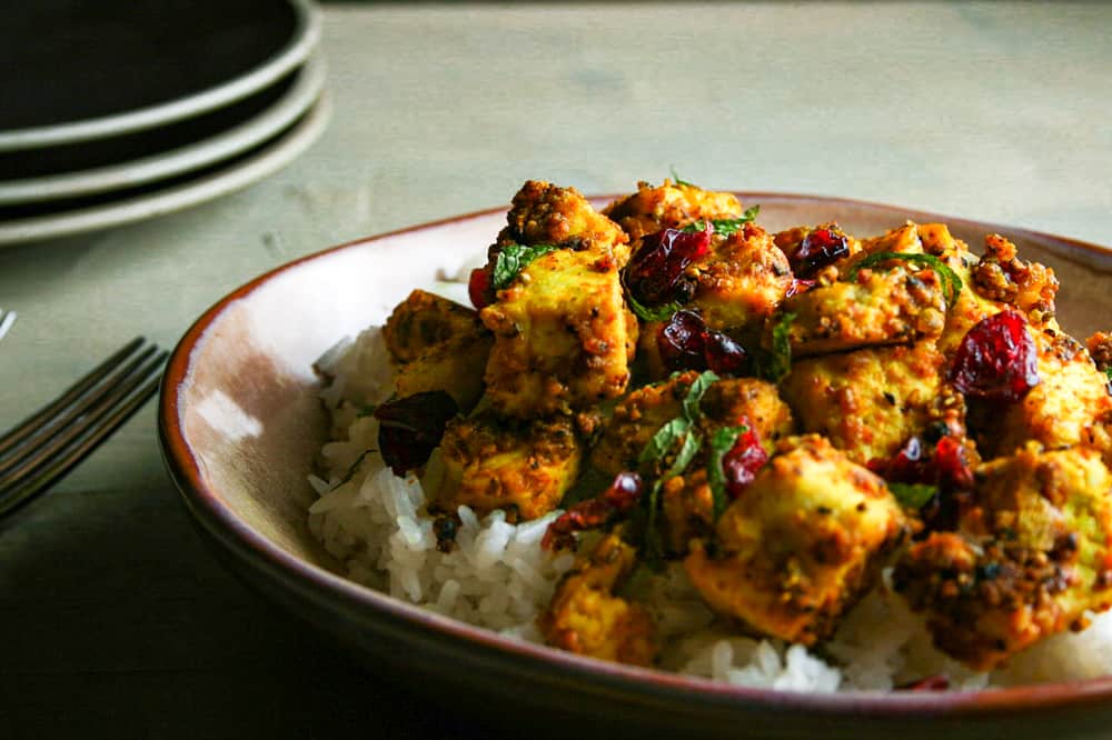 Close up photograph of turmeric and pepper spiced tofu served over rice