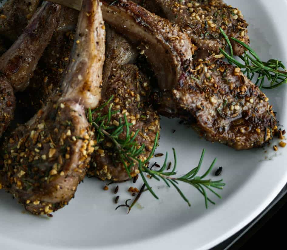 Rosemary Fennel Crusted Lamb Chops with springs of rosemary in the foreground. Lamb chop recipe. Recipes with rosemary. Los Angeles Lamb Chops