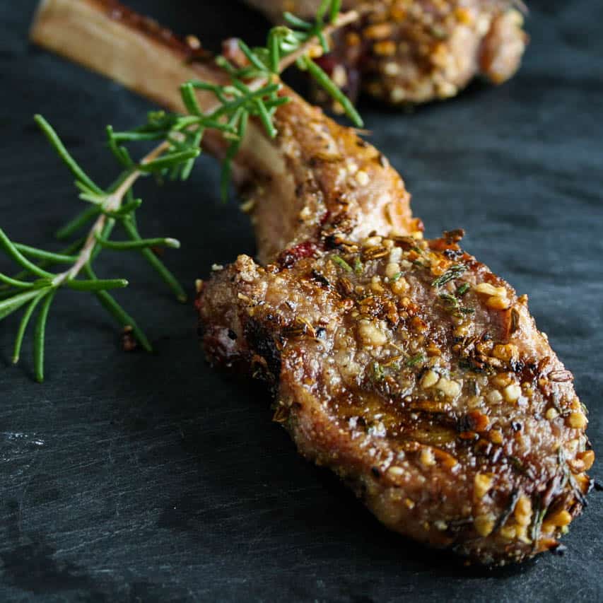 Rosemary Fennel Crusted Lamb Chops with springs of rosemary in the foreground. Lamb chop recipe. Recipes with rosemary. Los Angeles Lamb Chops