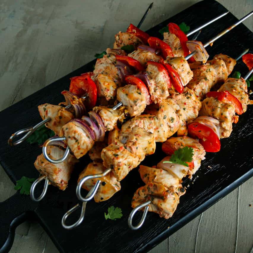 Stack of greek chicken kebabs on a black board. Greek yogurt marinated chicken kebab recipe. Chicken kebobs. 