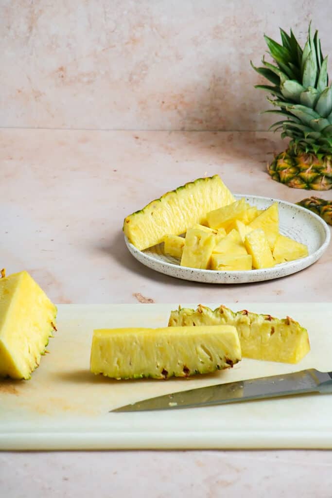 Process Photograph of chopping pineapple into chunks for vegan Jamaican jerk mushrooms skewers
