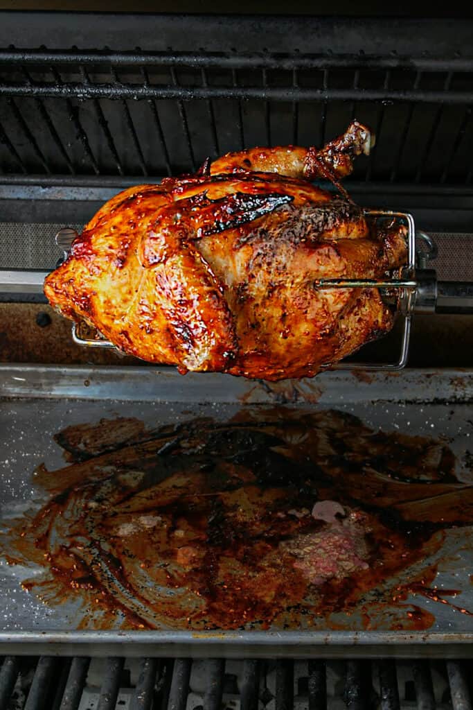 Cooking process shot of Chipotle raspberry bbq chicken. Shot on a rotisserie on the grill