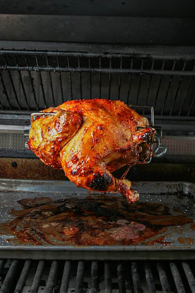 Cooking process shot of Chipotle raspberry bbq chicken. Shot on a rotisserie on the grill