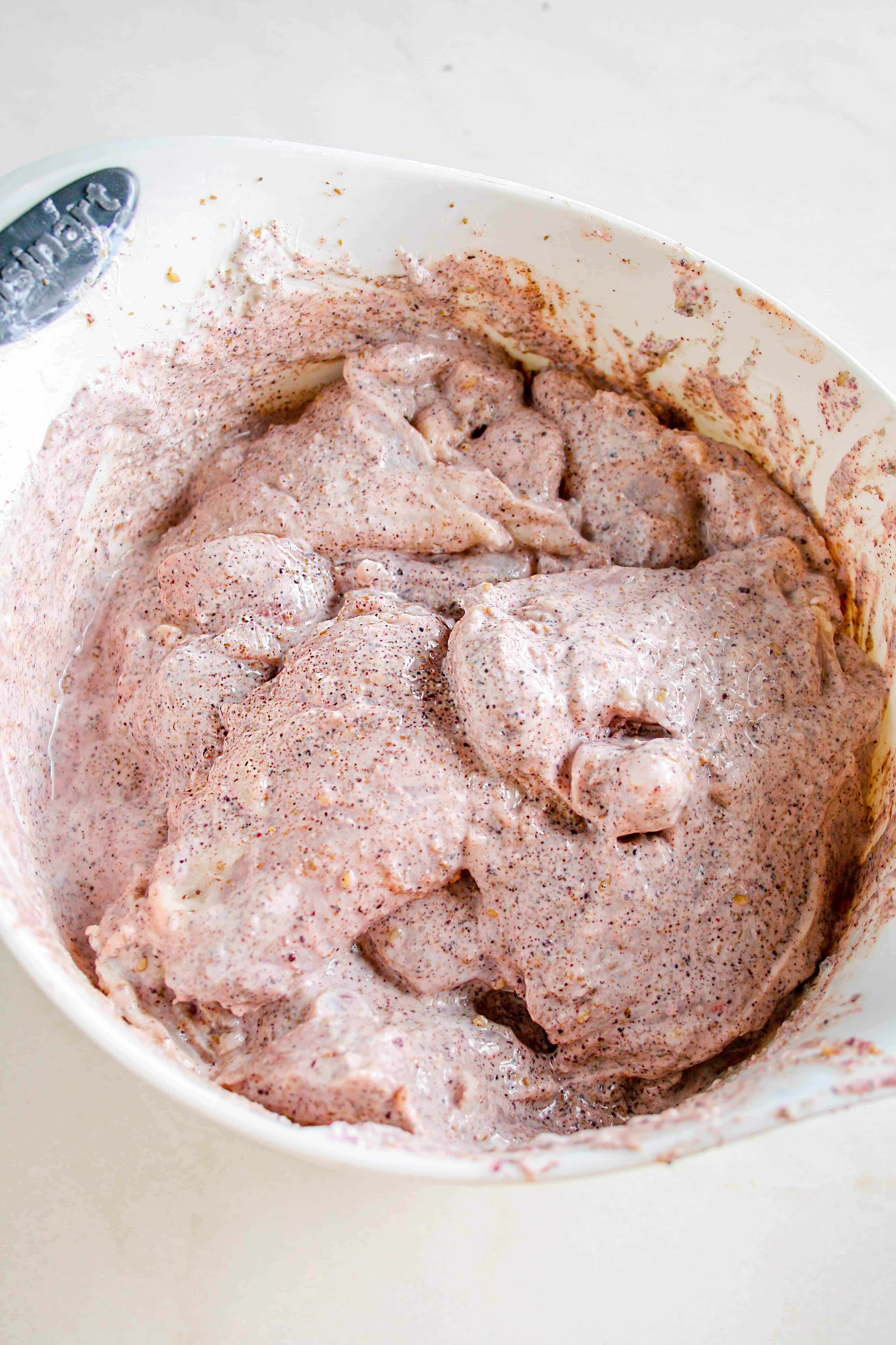 Process shot of chicken thighs in the marinade for the za'atar grilled chicken thighs