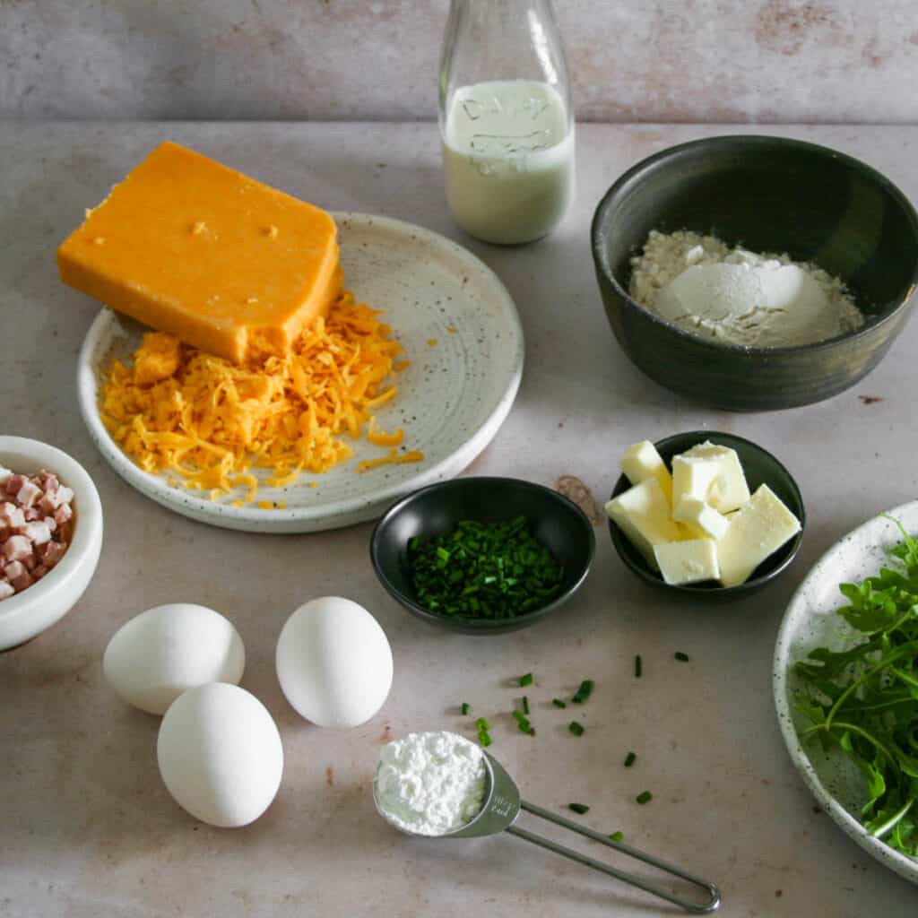ingredients for cheddar and chive savory dutch baby. Photographed on pink marble