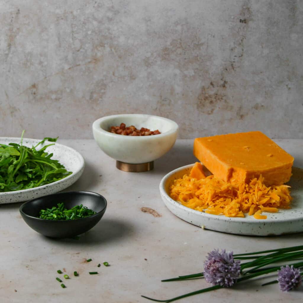 ingredients for cheddar and chive savory dutch baby. Photographed on pink marble