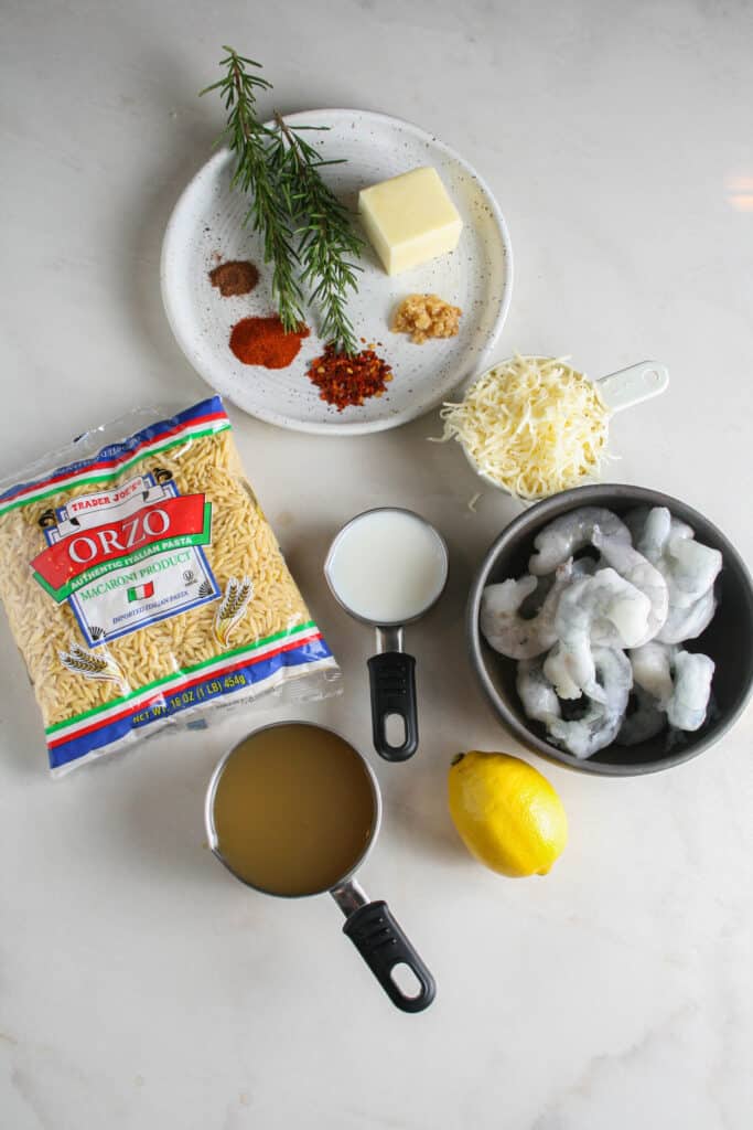 Ingredients for creamy rosemary orzo with shrimp. photographed on white Calcutta marble