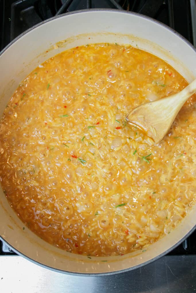 Photograph of orzo being cooked for 
creamy rosemary orzo with shrimp dish