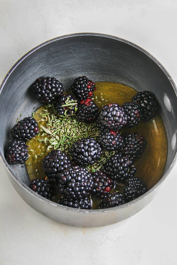 Photograph of honey being infused with blackberries and rosemary