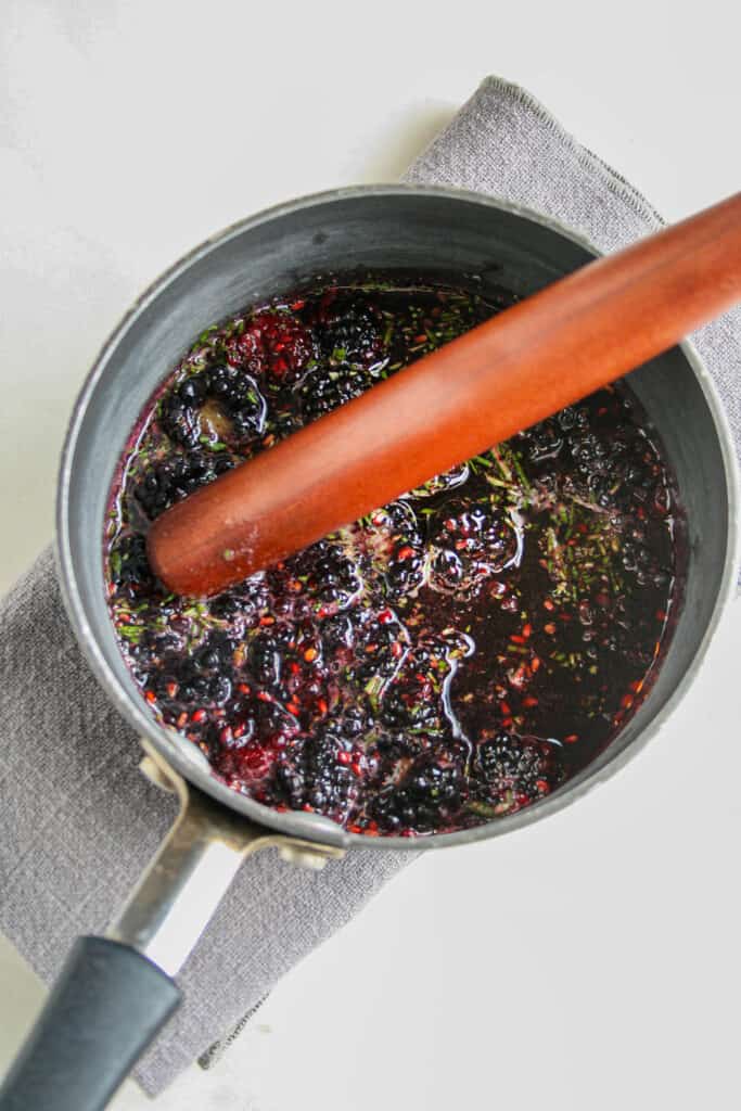 Photograph of honey being infused with blackberries and rosemary