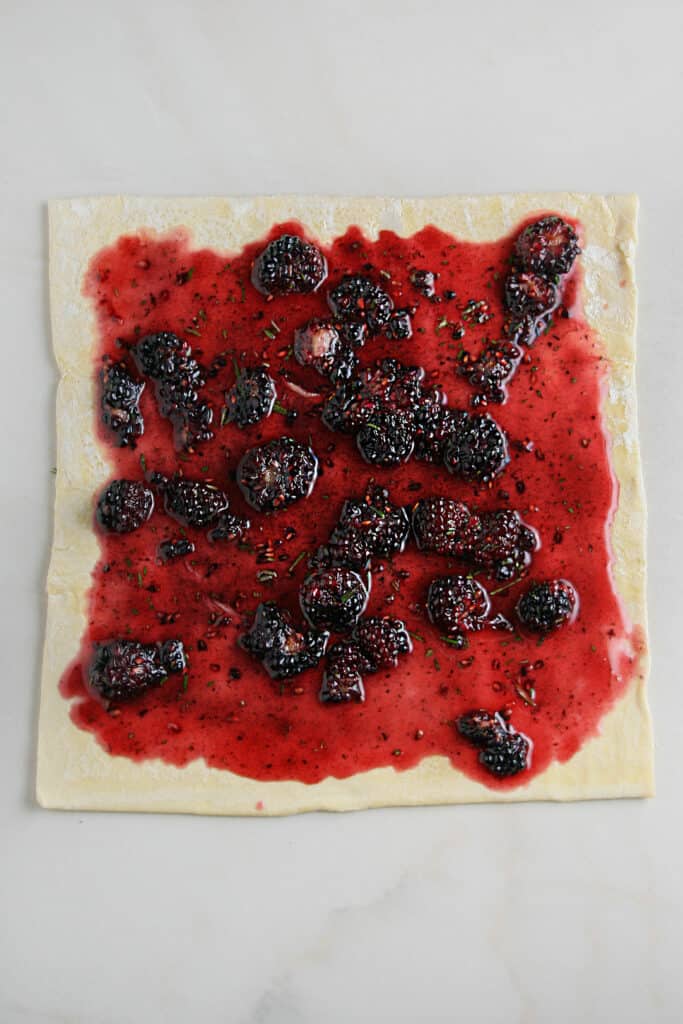 Blackberry honey spread out on puff pastry dough