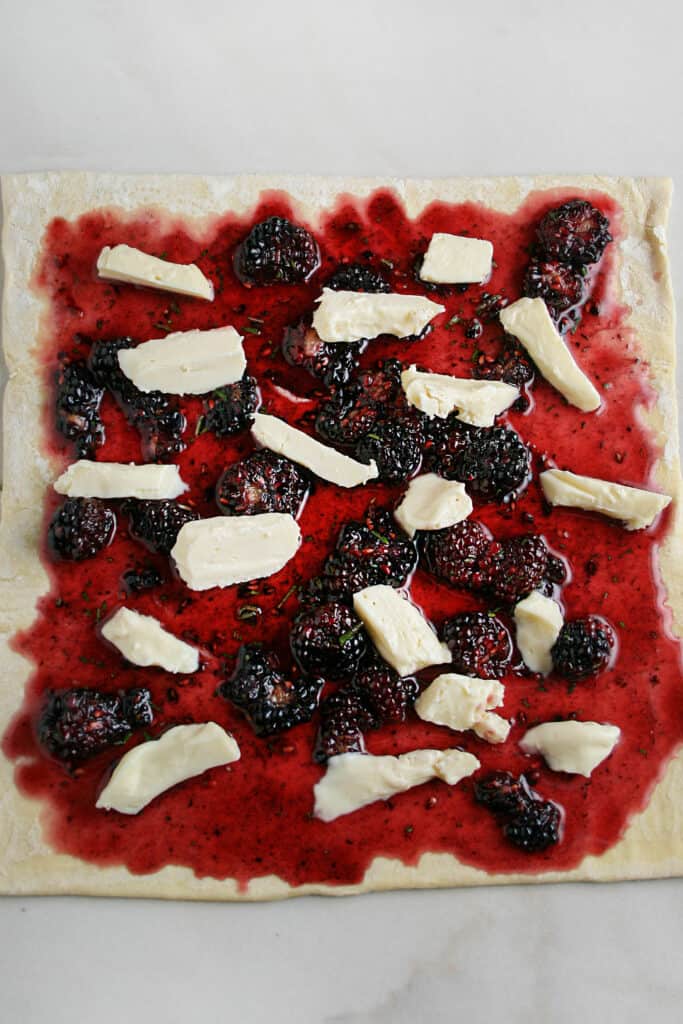 Blackberry honey and brie spread out on puff pastry dough