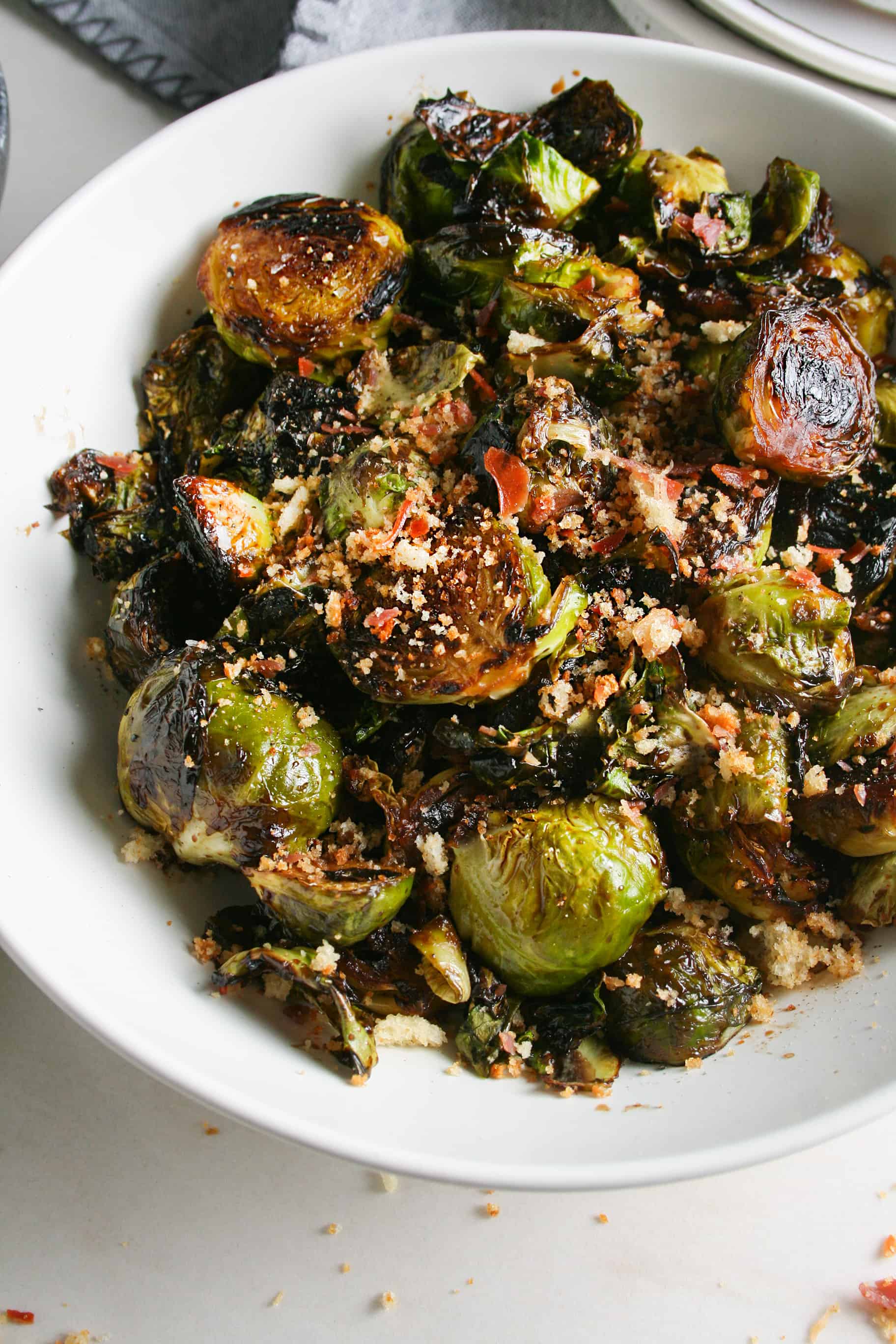 Red Wine Pan Fried Brussels sprouts photographed in a white shallow bowl