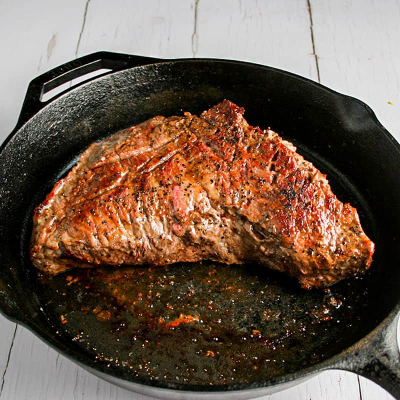 Flank steak cooked on a cast iron pan