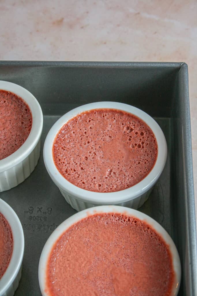 Ramekins filled with red velvet creme brulee custard after baking