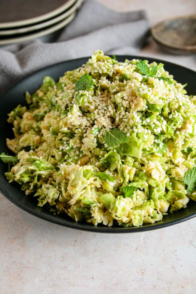 Close up photo of Miso brussels sprout salad in a black bowl