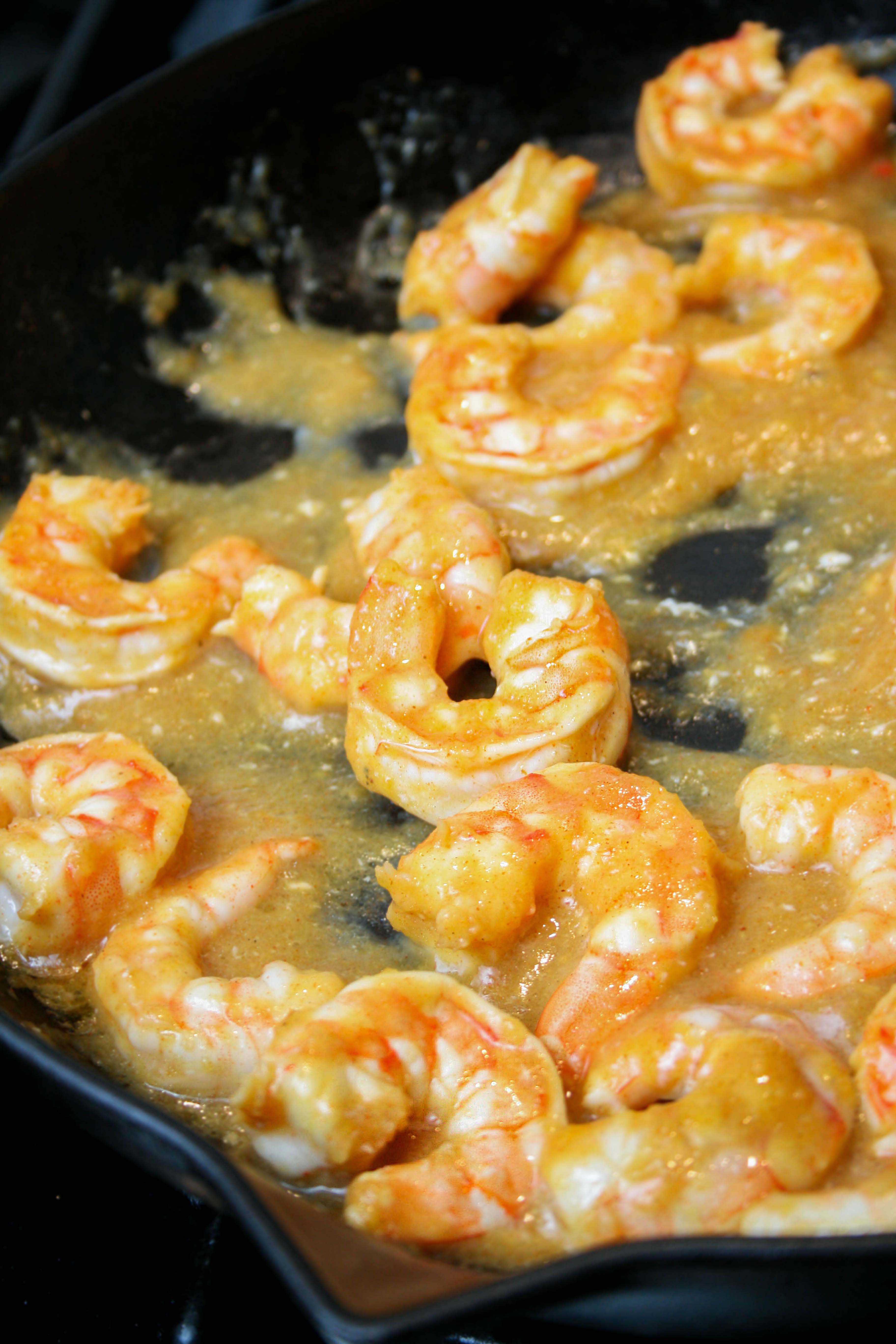 cooking shrimp on a cast iron skillet in chili mango sauce