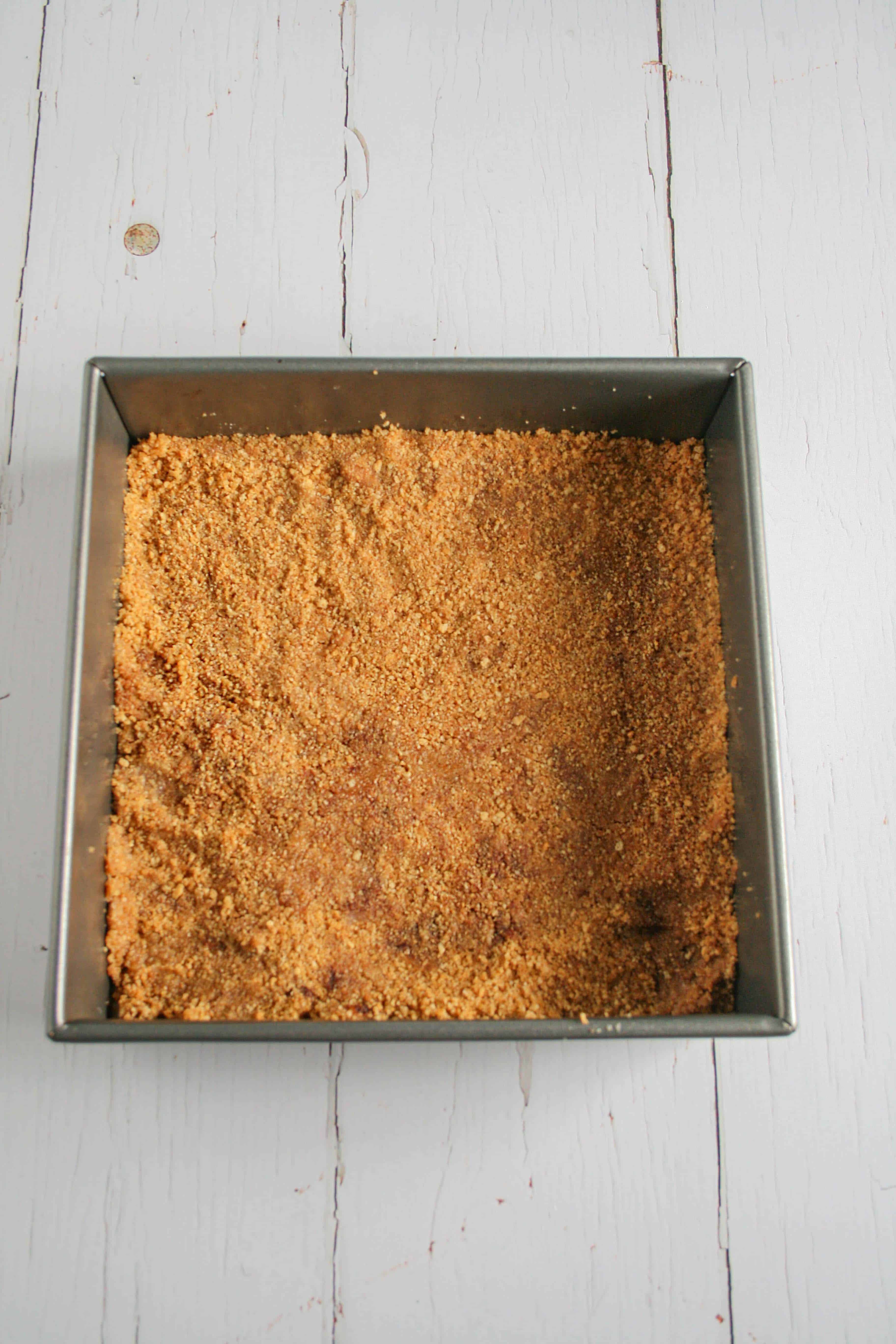 Graham cracker crust packed into a baking dish
