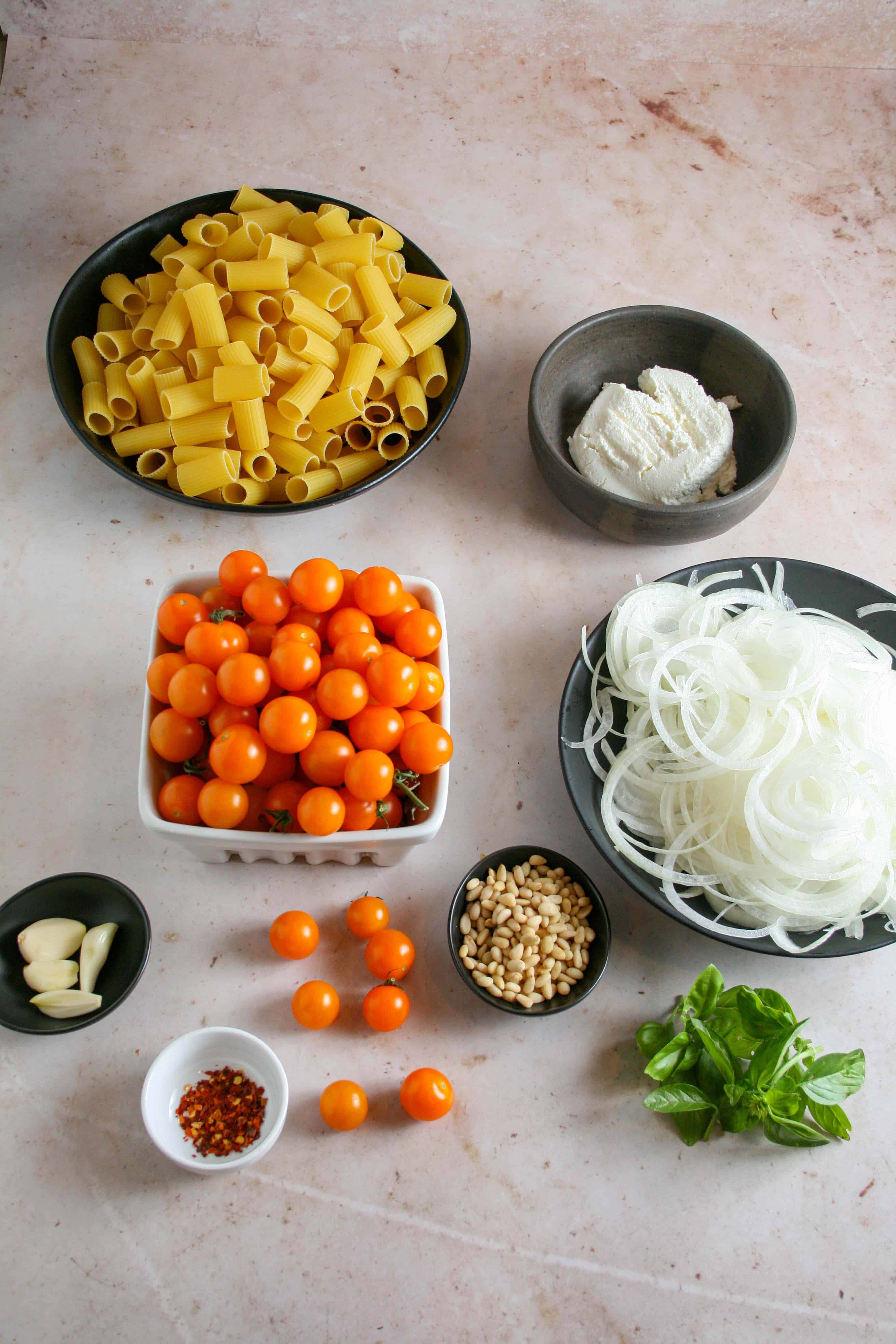 Ingredients for caramelized onions and sun gold tomato pasta