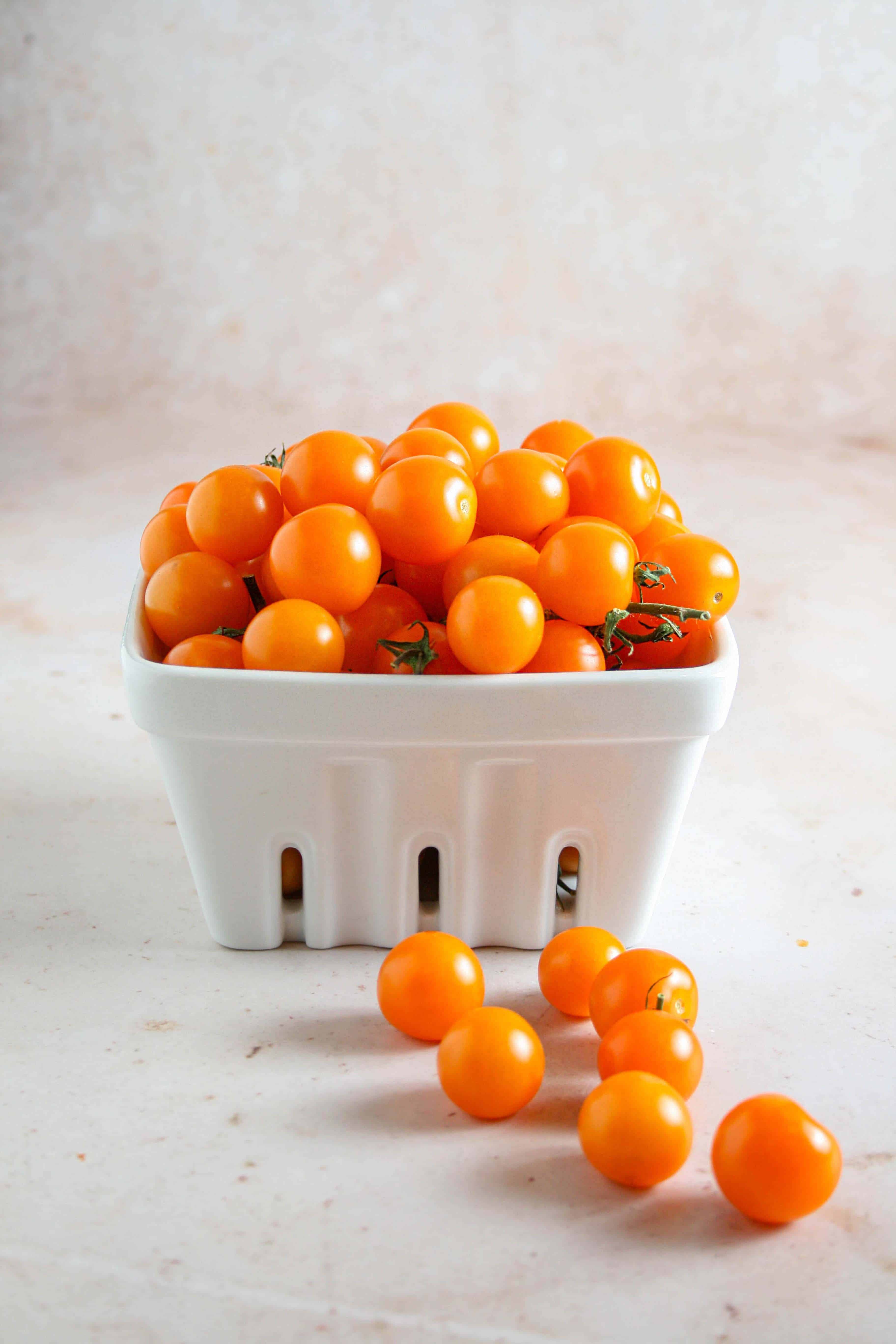 Photograph of sun gold tomatoes in a white ramekin 