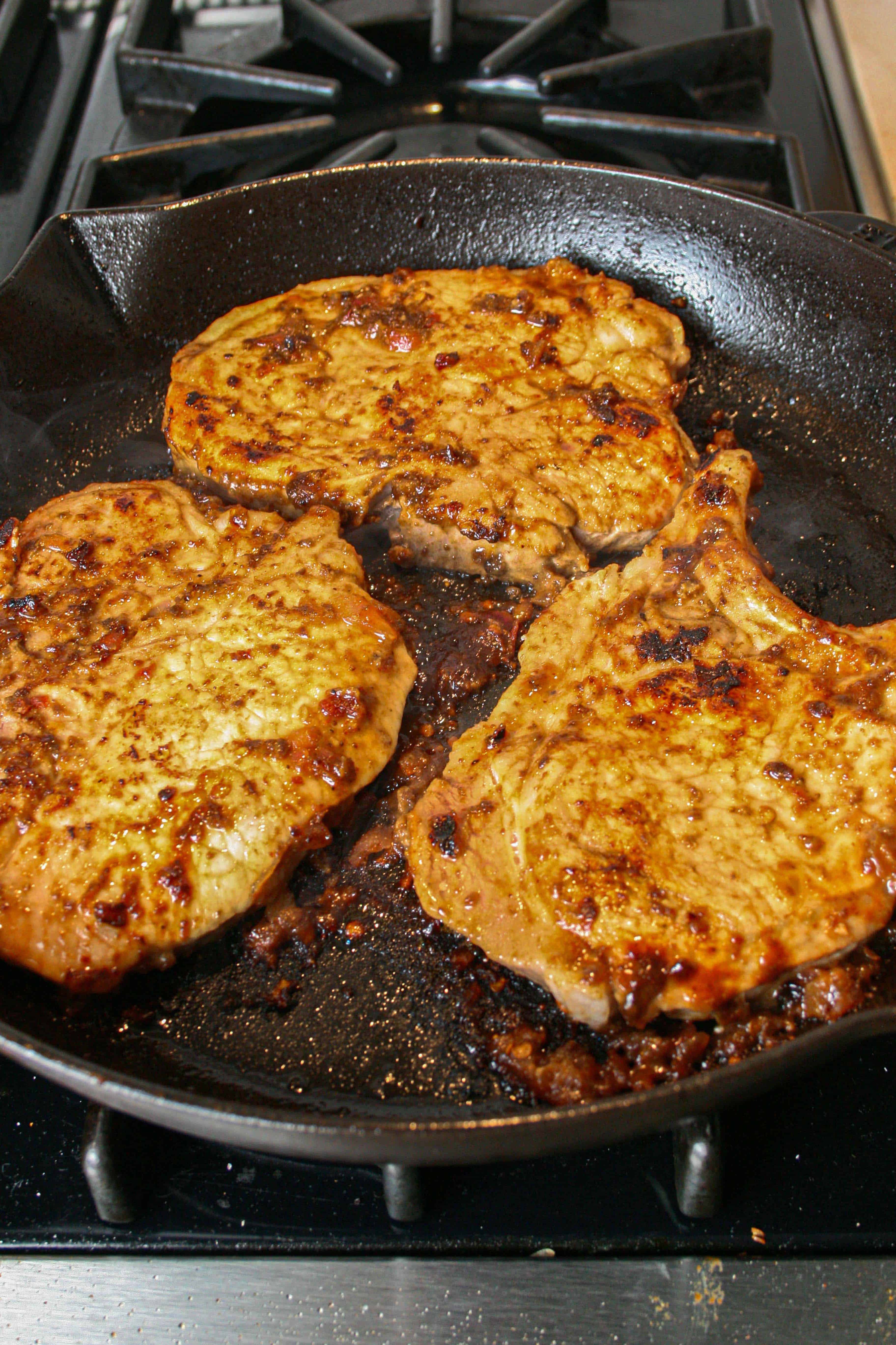 Pork Chops with Fig sauce cooking on a cast iron skillet
