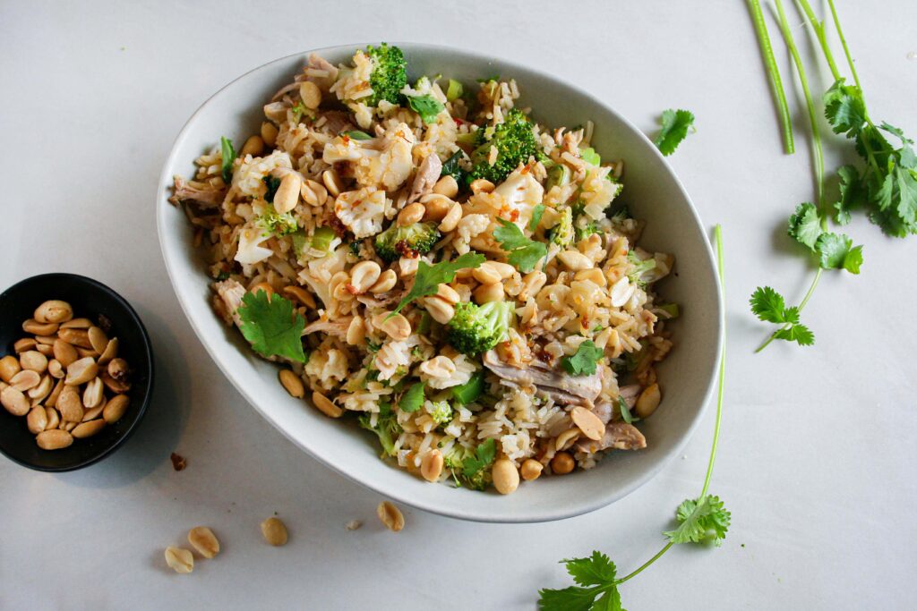 Hero photograph of chili peanut chicken pilaf with cilantro and peanuts on the side
